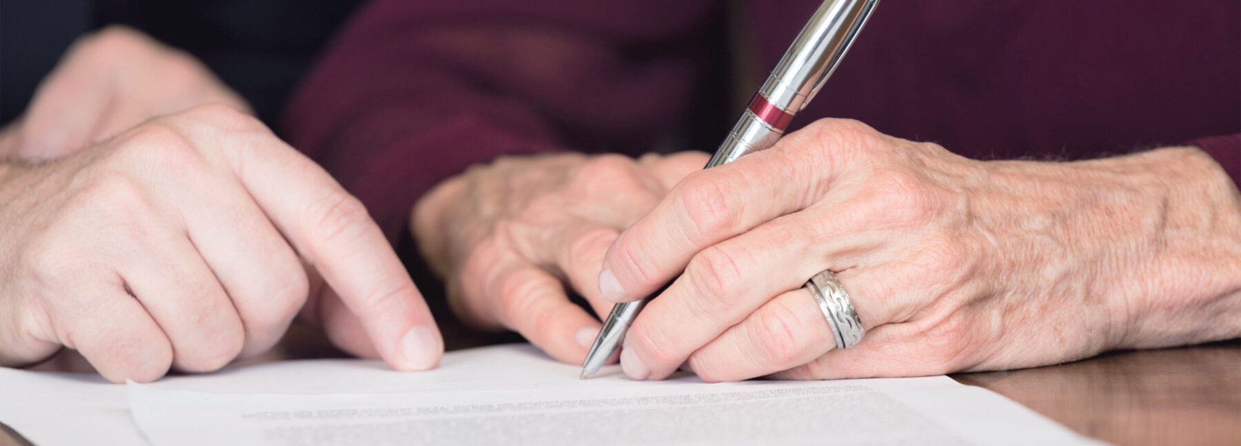 elderly person signing probate document
