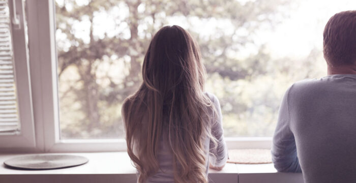 couple stood looking outside window