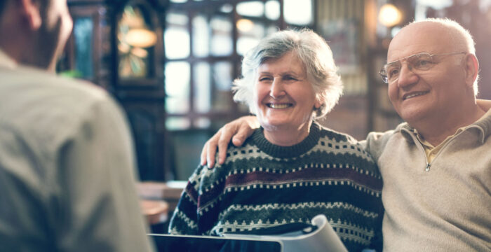 elderly couple talking to man