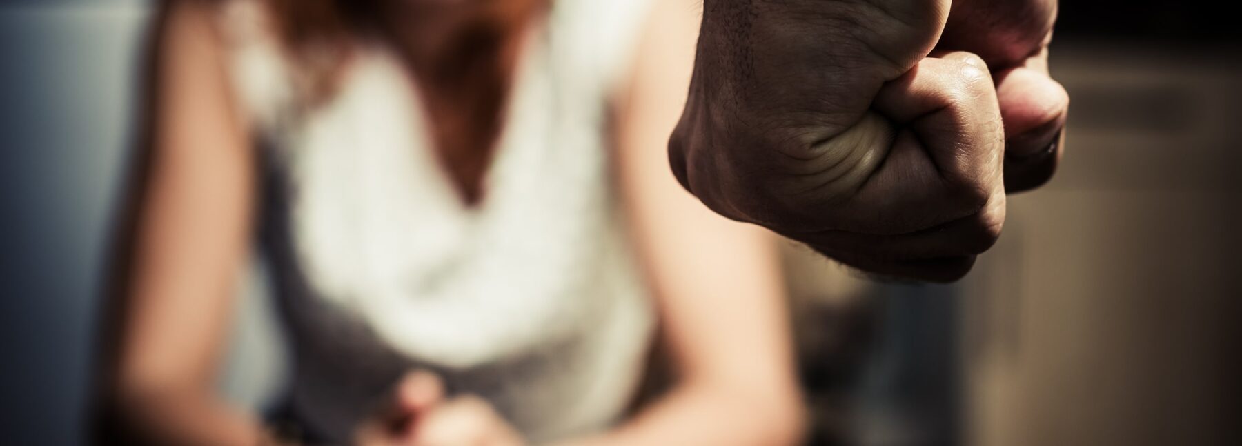 lady visibly threatened with fist in forefront