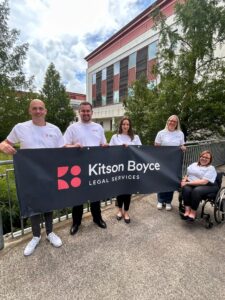Kitson Boyce team members holding banner 