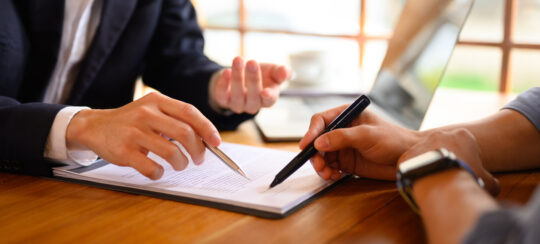 close up of lawyer and client signing document