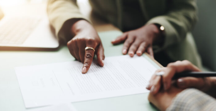 close up of people pointing at a printed documents