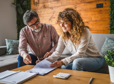 senior man instructs adult woman to sign contract