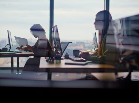 employees sat at desks in high rise corporate office
